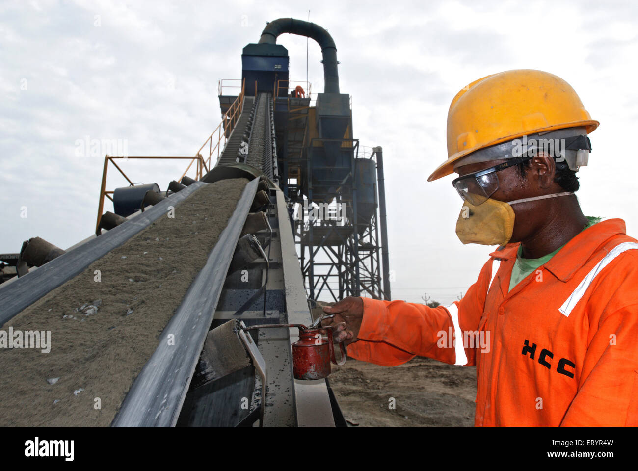 Lavoratore in maschera protettiva e bicchieri su impianto di miscelazione asfalto a tamburo ; Madras ; Chennai ; Tamil Nadu ; India ; Asia Foto Stock