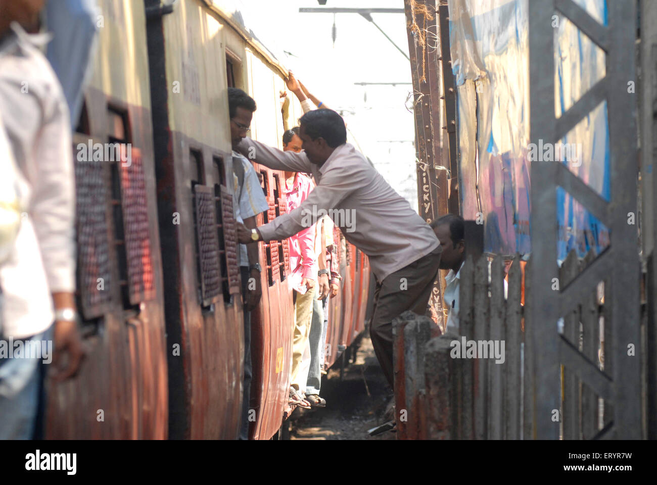 Persone che si immettono in treno autobus ferroviario pericolosamente , Bombay , Mumbai , Maharashtra , India , Asia Foto Stock