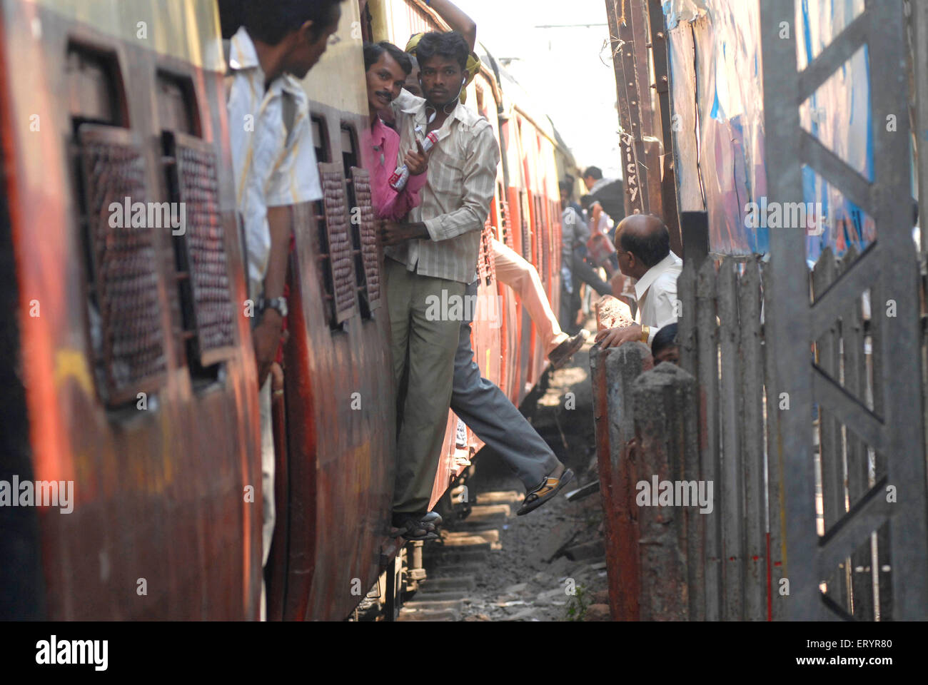 Persone che si immettono in treno autobus ferroviario pericolosamente , Bombay , Mumbai , Maharashtra , India , Asia Foto Stock