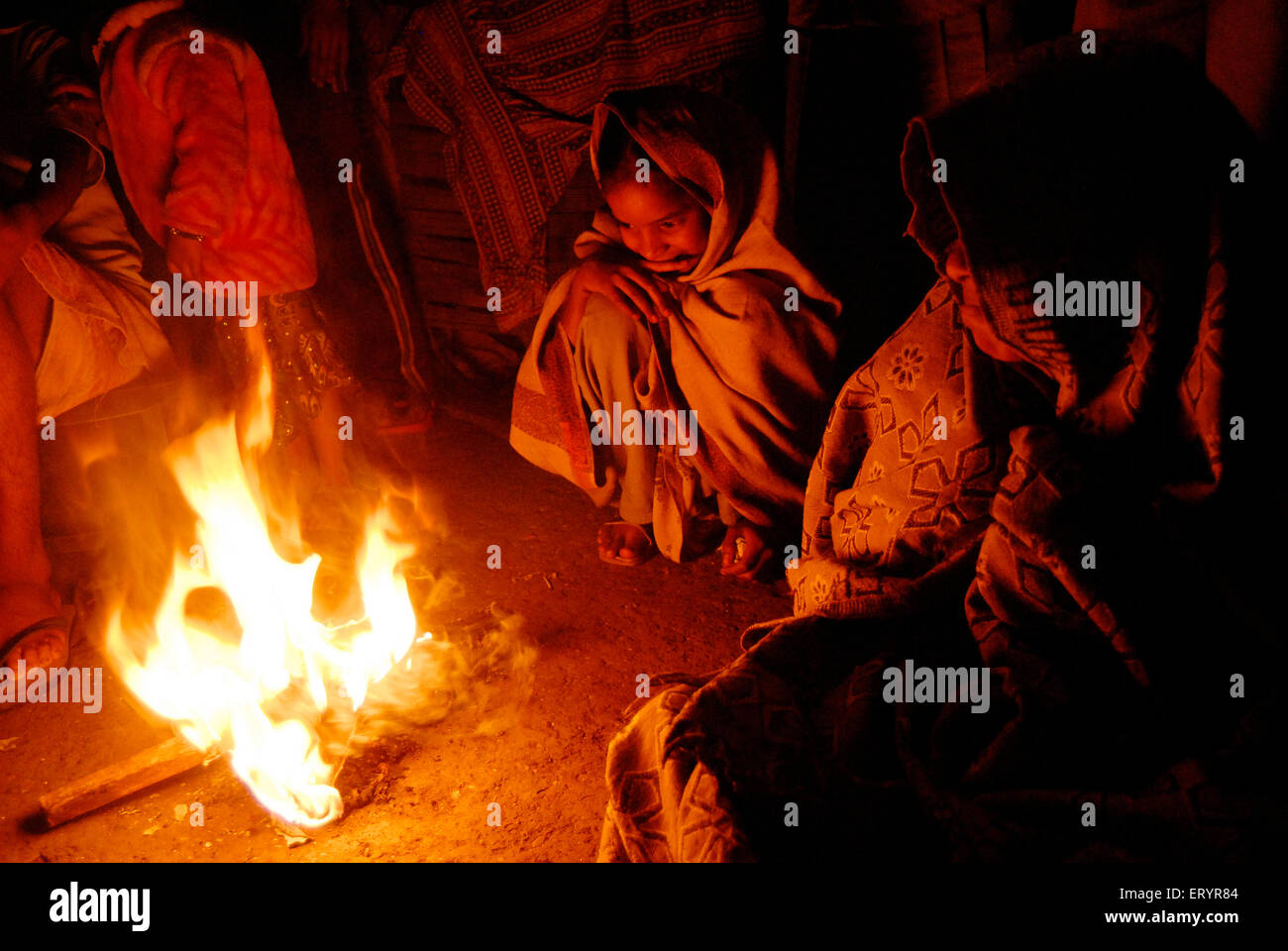 Persone che si siedono intorno al riscaldamento del falò nella stagione invernale , Bombay , Mumbai , Maharashtra , India , Asia Foto Stock