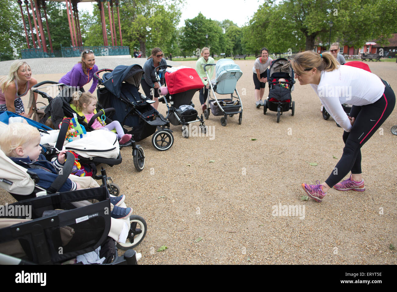 La Madre ha tenuto un esercizio di classe con baby e bimbo a nei loro passeggini in un parco in London, England, Regno Unito Foto Stock
