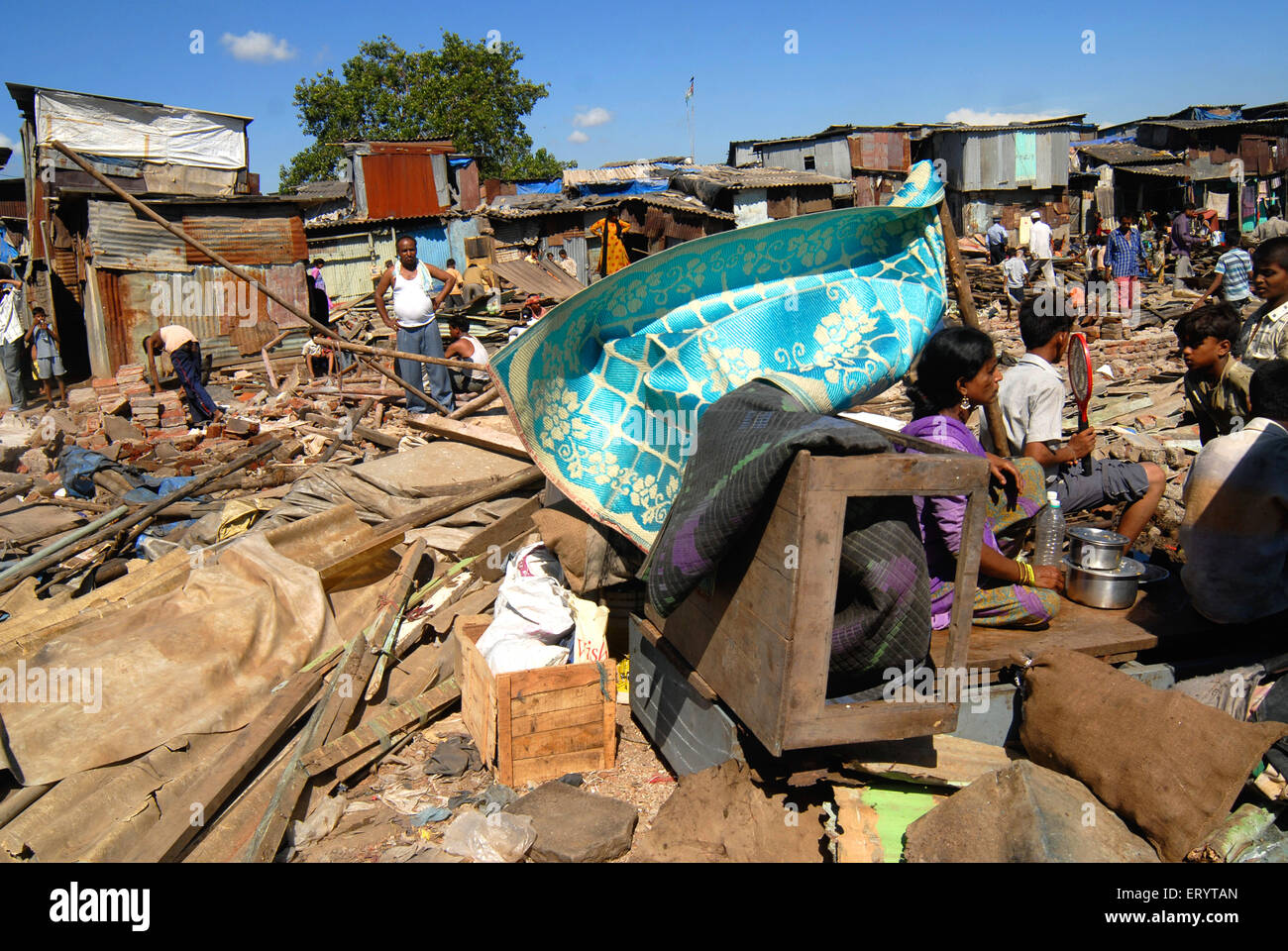Gli abitanti degli slum di sedersi con i loro averi dopo la demolizione delle baraccopoli in aeroporto Sahar Chatrapati Shivaji International Airport Foto Stock