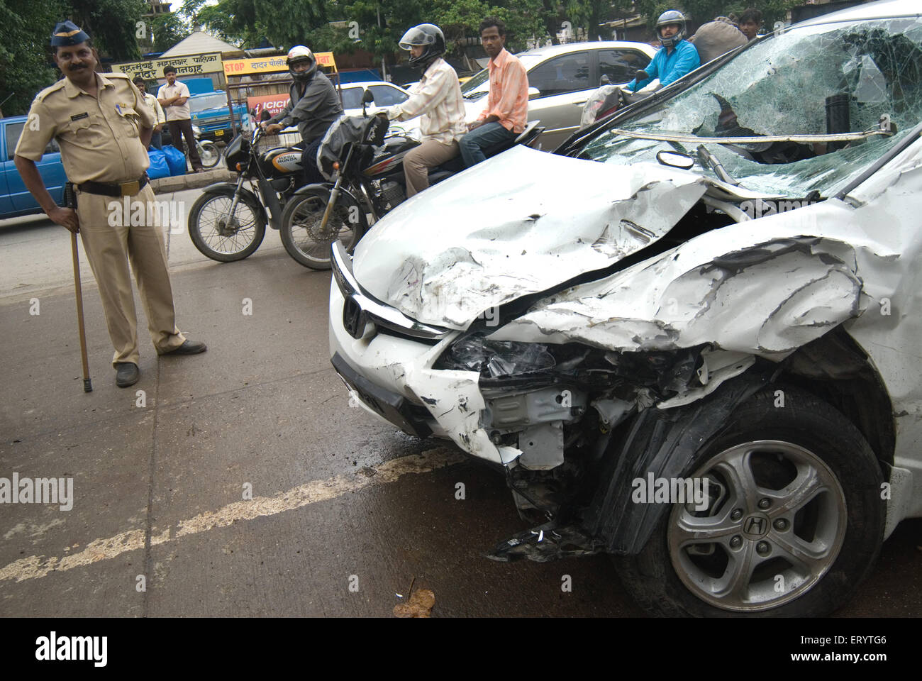 Persone che guardano la vettura danneggiata in un incidente a Bombay Mumbai ; Maharashtra ; India Foto Stock