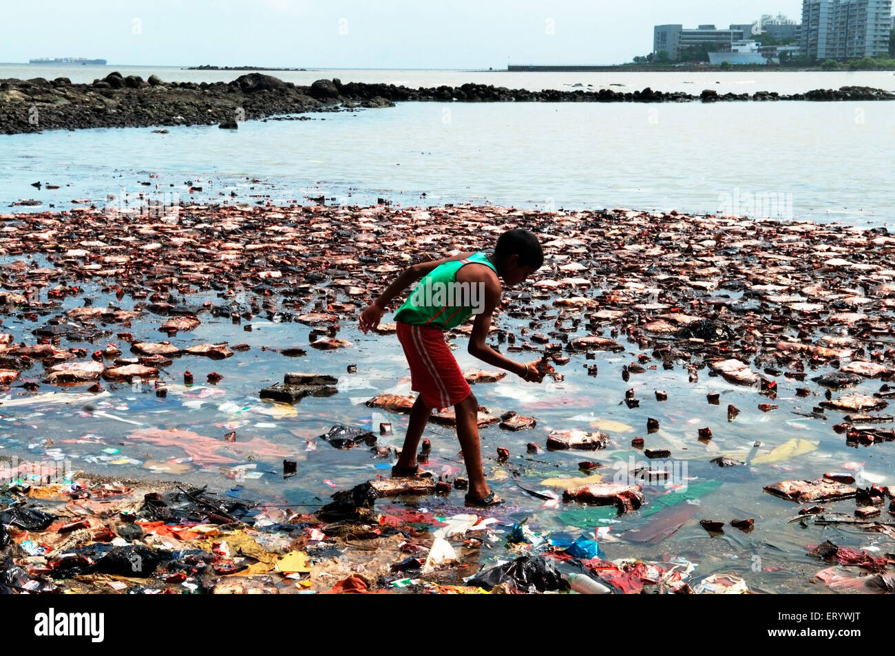 Ragazzo alla ricerca di pacchetti di biscotti da imbevuti di olio a causa di portacontainer chitra collidere in mare Mumbai Bombay Foto Stock