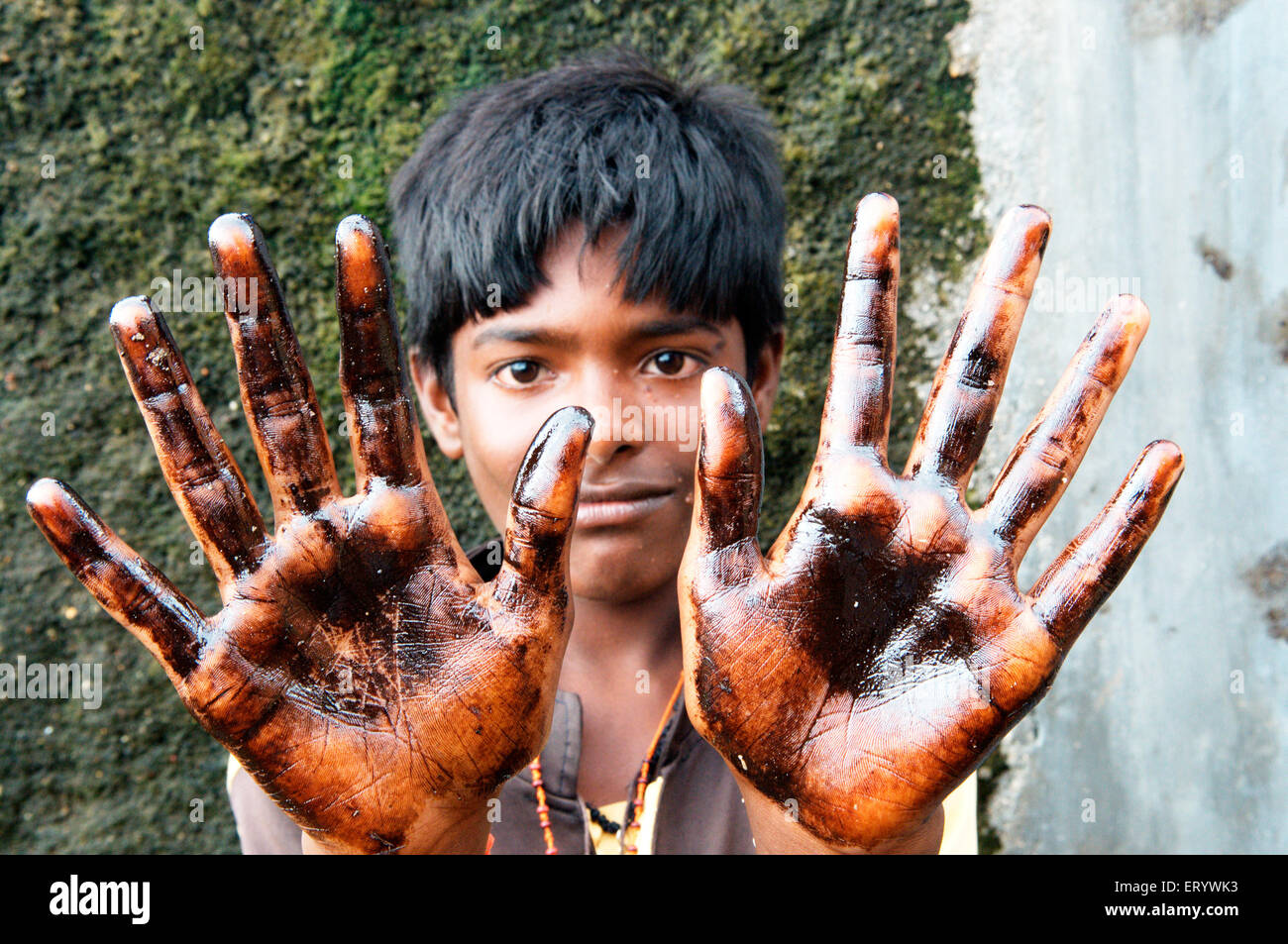 Ragazzo che mostra l'olio imbevuto palm a causa di portacontainer chitra collidere in mare Mumbai Bombay ; Maharashtra ; India NOMR Foto Stock