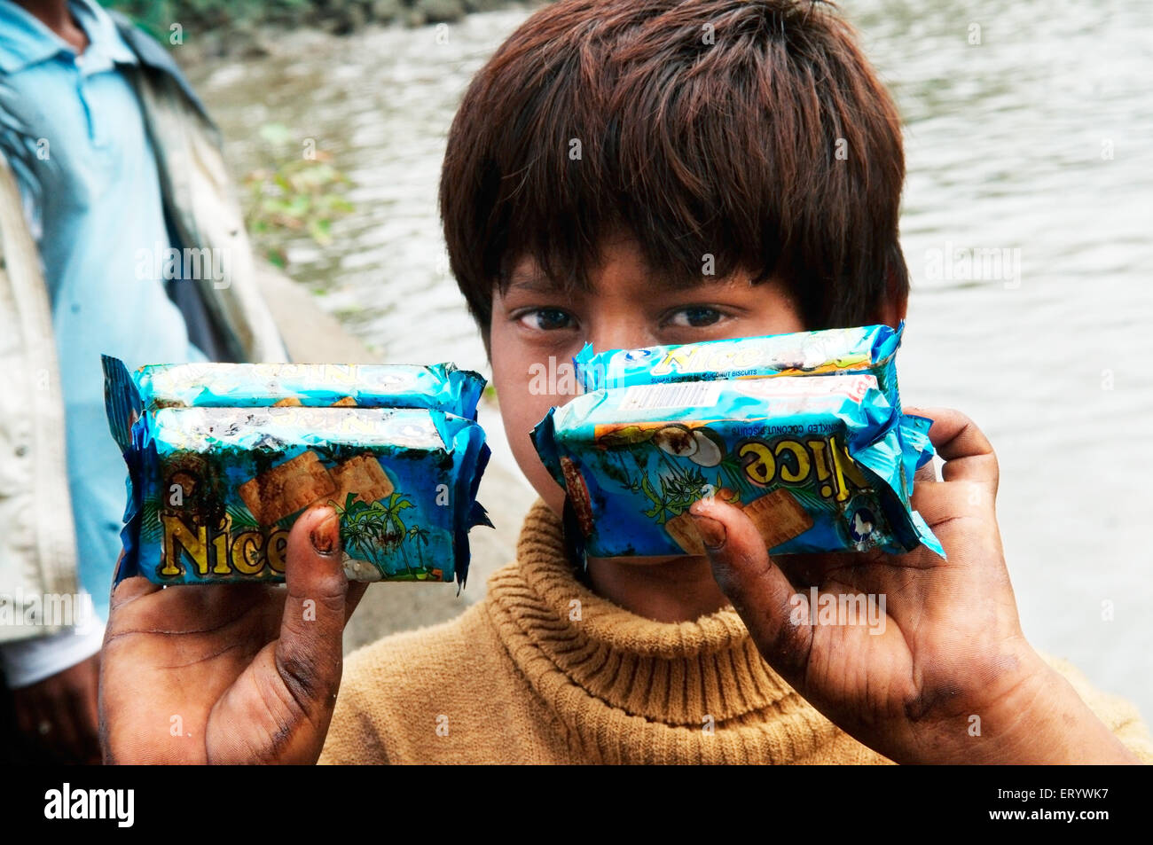 Ragazzo che mostra l'olio biscotto impregnato di pacchetti a causa di portacontainer chitra collidere in mare ; Mumbai Maharashtra Foto Stock