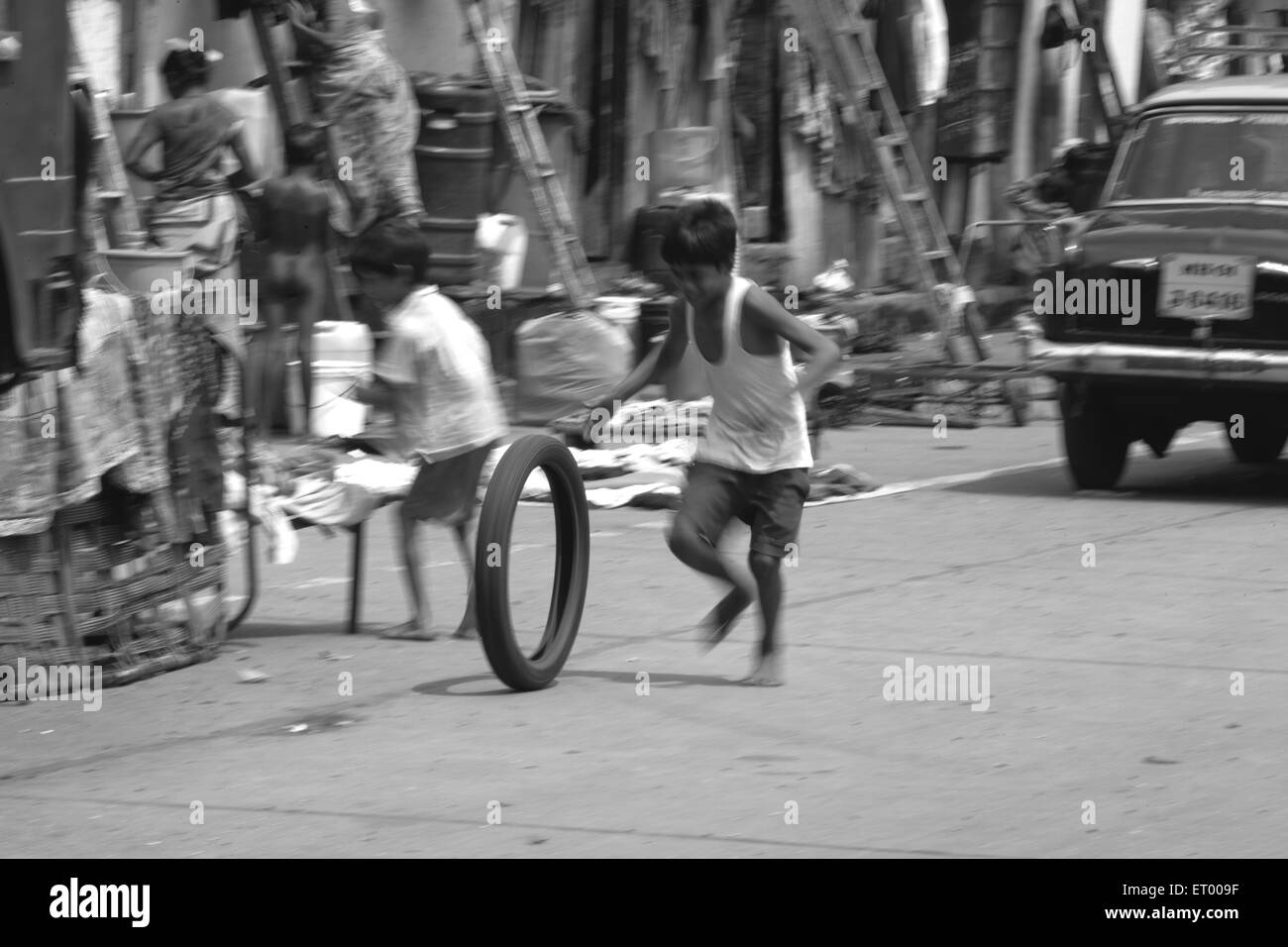 Ragazzo giocando con pneumatico Byculla baraccopoli N M Joshi Road Bombay Mumbai India Maharashtra Foto Stock