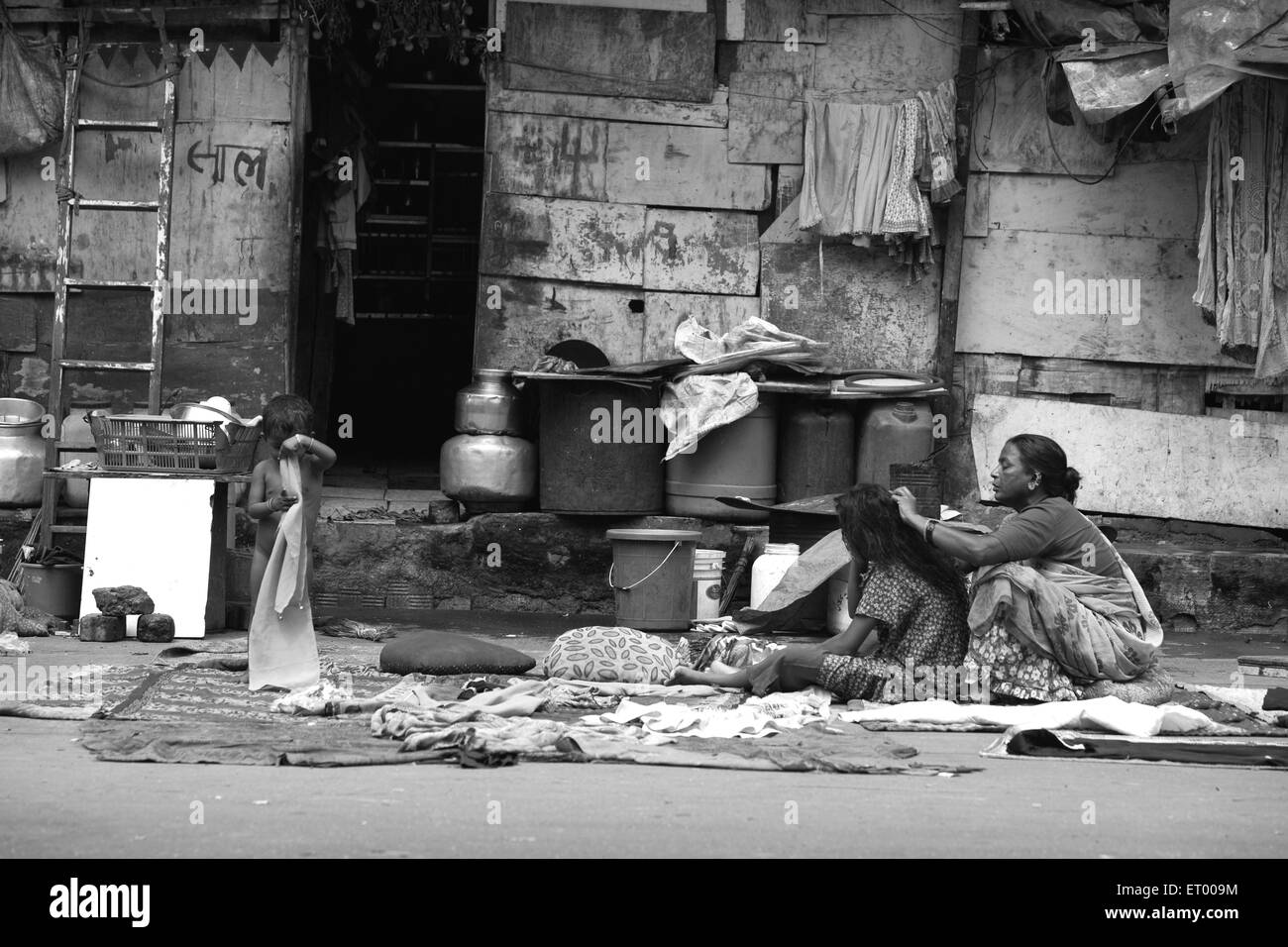 Abitanti di baraccopoli donna pettinatura capelli ragazza Byculla slum N M Joshi Road Bombay Mumbai Maharashtra India baraccopoli indiani Foto Stock