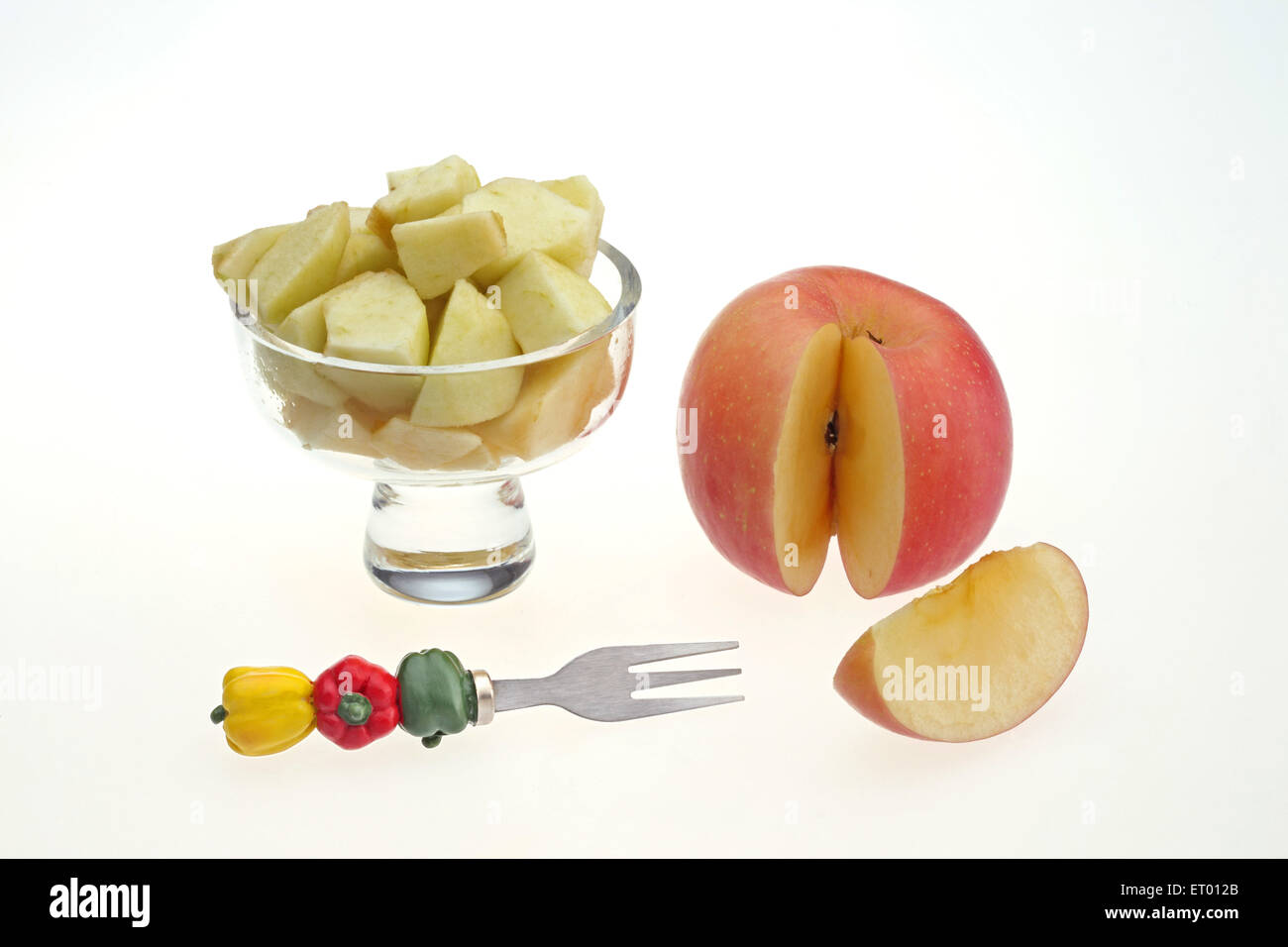 Apple latino Malus pumila pezzi in una coppa di frutta con Frutto decorativo forcella e una mela tagliata fetta ; India Foto Stock