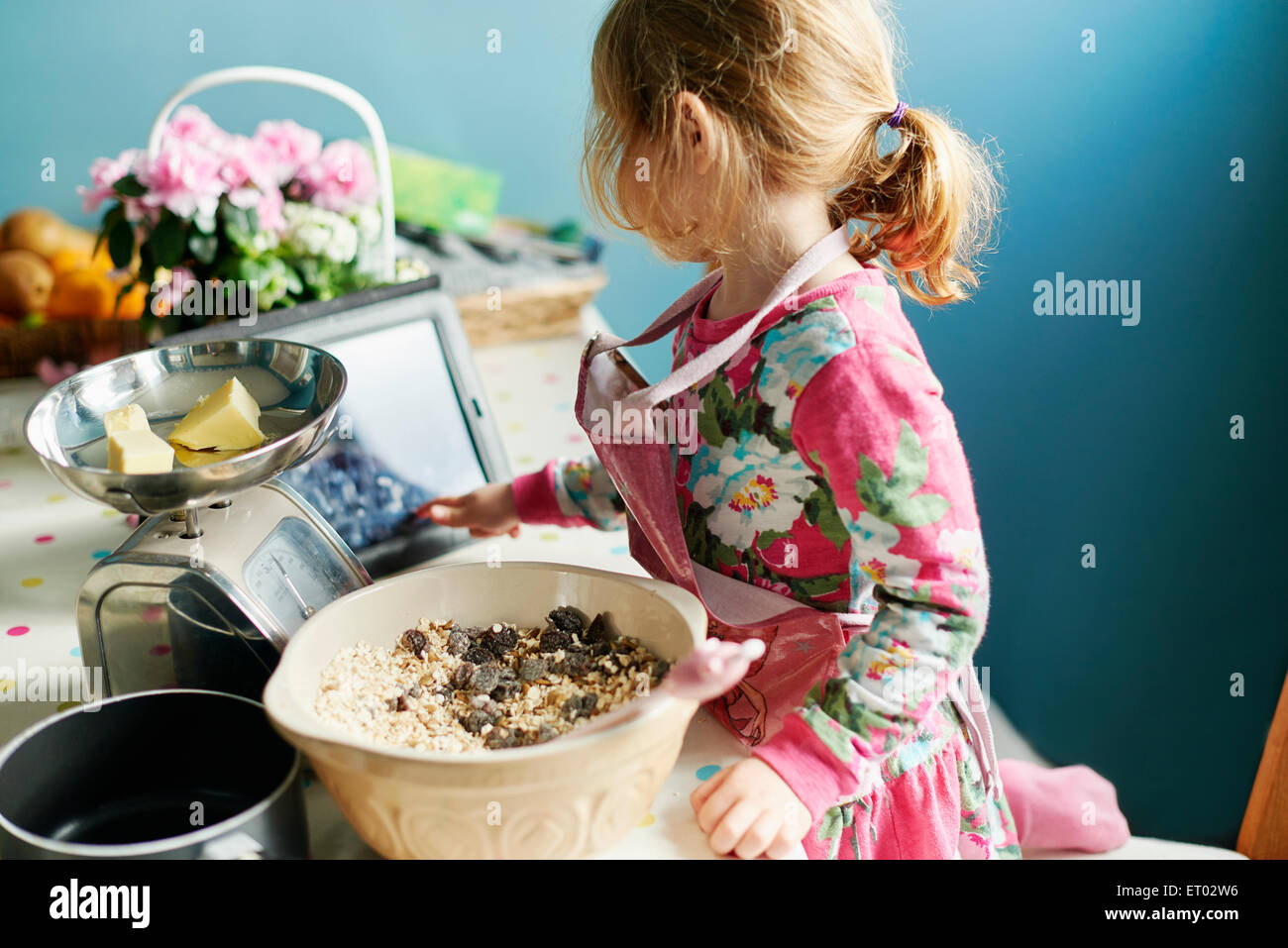 Ragazza con tavoletta digitale la cottura in cucina Foto Stock