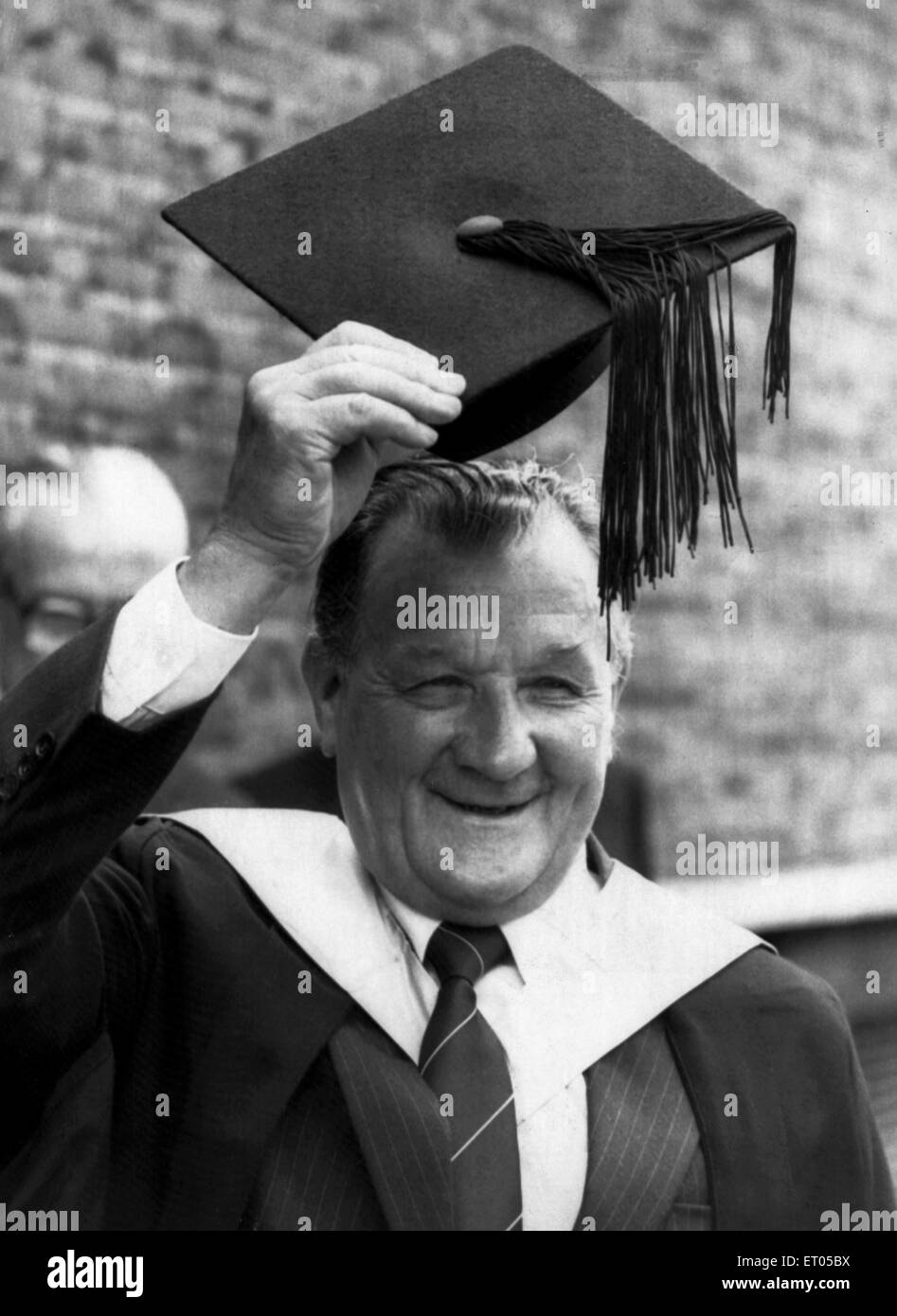 Ex manager di Liverpool Bob Paisley solleva la sua scheda di malta dopo essere stato realizzato un titolo onorario di Master of Science in un grado giorno tenutasi in Liverpool Philarmonic Hall. 8 luglio 1983. Foto Stock