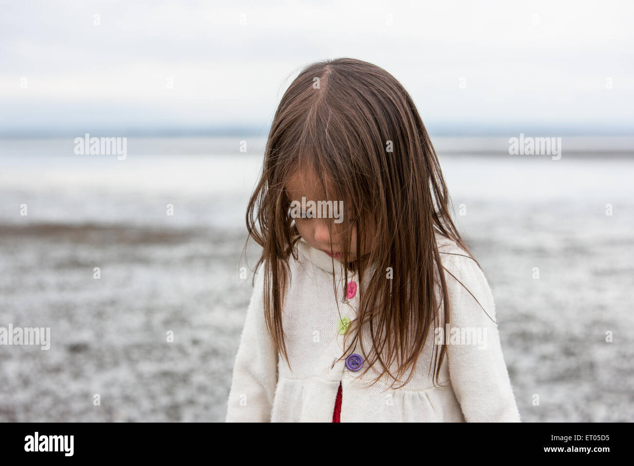 Bruna ragazza guardando giù in spiaggia Foto Stock