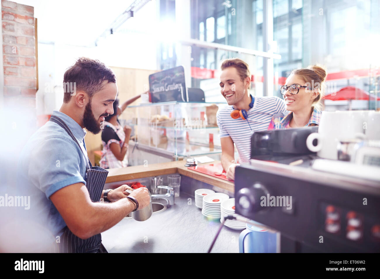 I clienti guarda la barista fare il caffè nella caffetteria Foto Stock