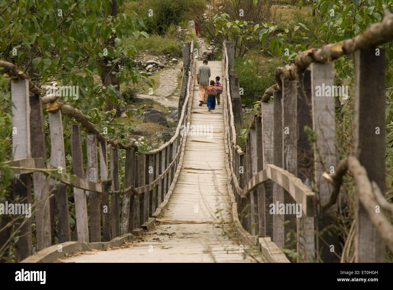 Scuola Bambini che attraversano il ponte di legno sul fiume Beas Himachal Pradesh India Asia Foto Stock