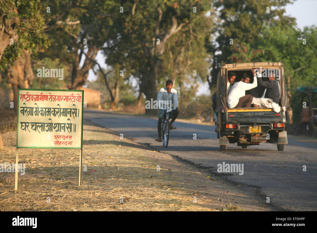 Ciclo e tempo su strada, campagna di garanzia del lavoro cartello, Lohardaga, Ranchi, Jharkhand, India, Vita rurale indiana Foto Stock