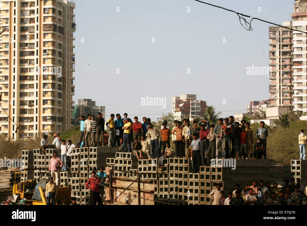 Folla in piedi su materiale da costruzione, Versova, Andheri, Bombay, Mumbai, Maharashtra, India, Asia Foto Stock