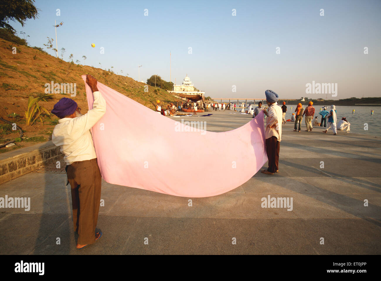 La religione sikh devoti tradizionale di essiccazione lungo 6 metri copricapo o su 15 km di lunghezza Ghat del fiume Godavari dopo la santa bagno ; Nanded Foto Stock