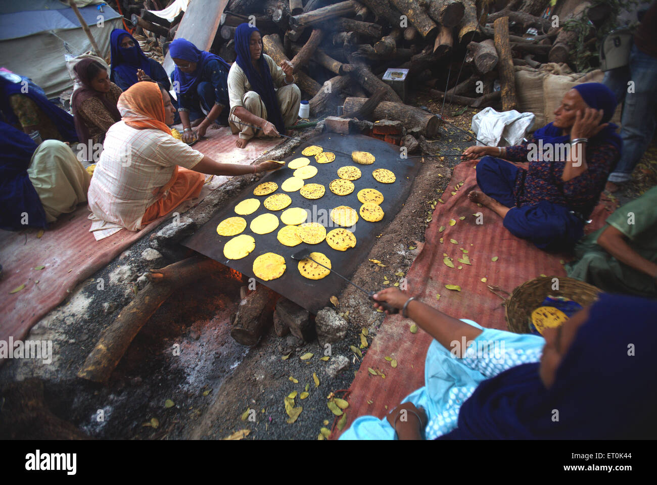 La religione sikh devoti rendendo makai di rotis farina di mais pane cucina ;perpetuo Guru Granth Sahib ; Sachkhand Saheb Gurudwara in Nanded Foto Stock