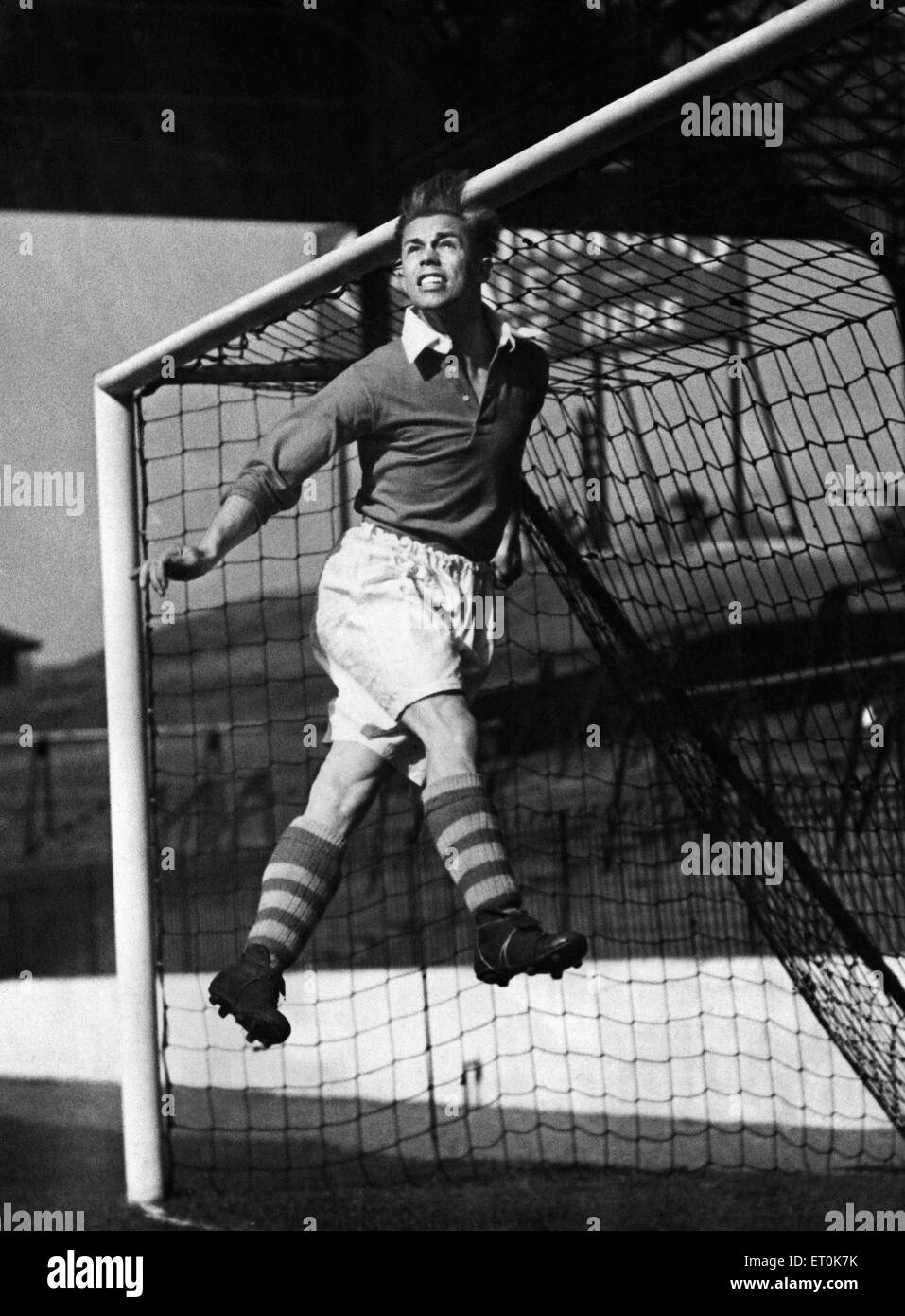 Charlton Athletic metà sinistra Bert Johnson pratica rubrica la palla fuori da sotto la traversa durante una sessione di formazione a valle. Il 10 ottobre 1946. Foto Stock