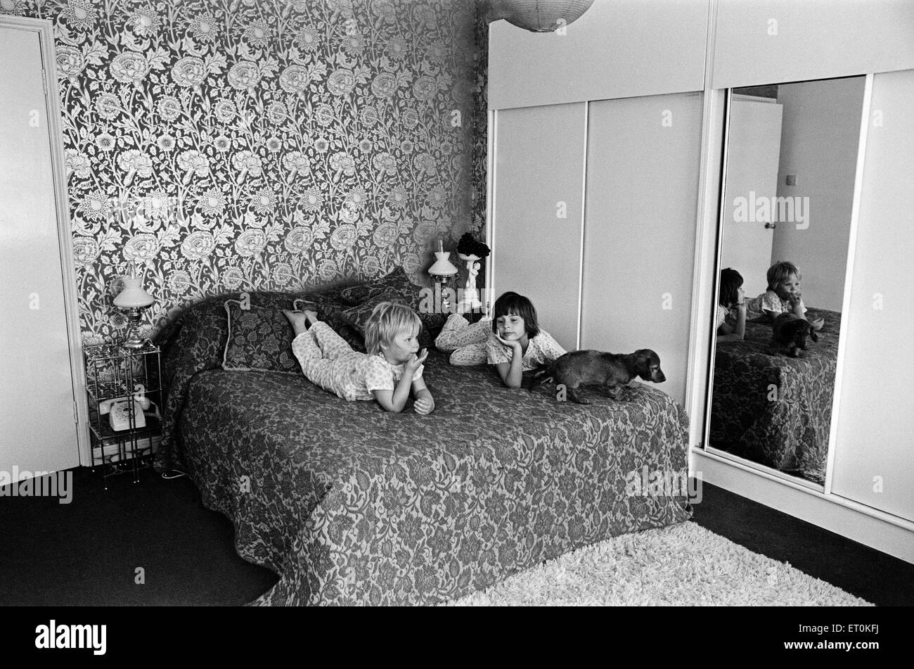 Due bambini e un cane su un letto in una visualizzazione di una moderna camera da letto, 12 maggio 1969. Anni Settanta interior design per Foto Stock