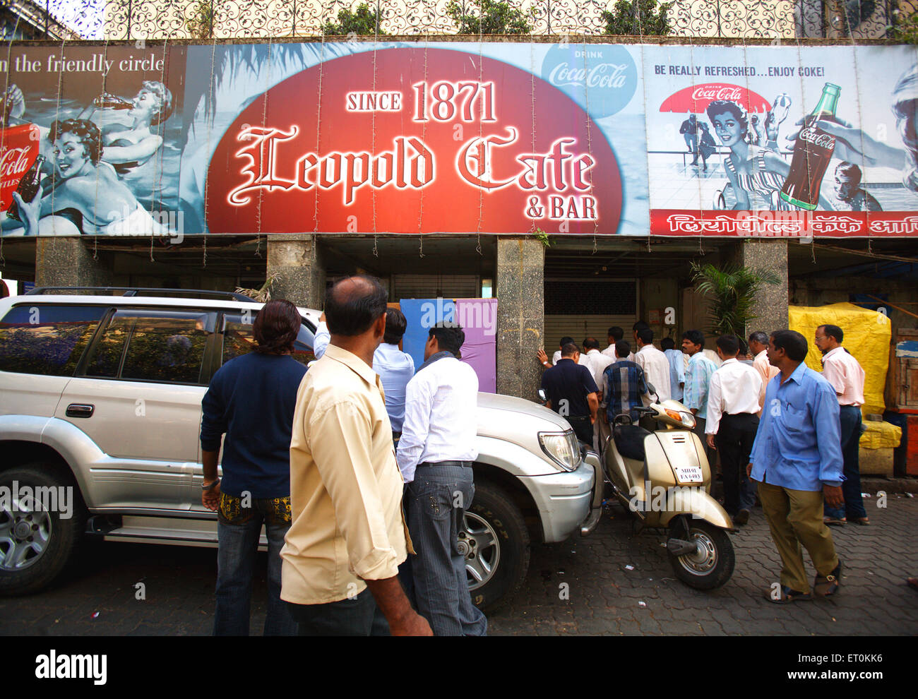 Curiosi guardando le perdite fatto a Leopold Caf' dopo l attacco terroristico da Deccan Mujahedeen di Colaba ; Bombay Mumbai Foto Stock