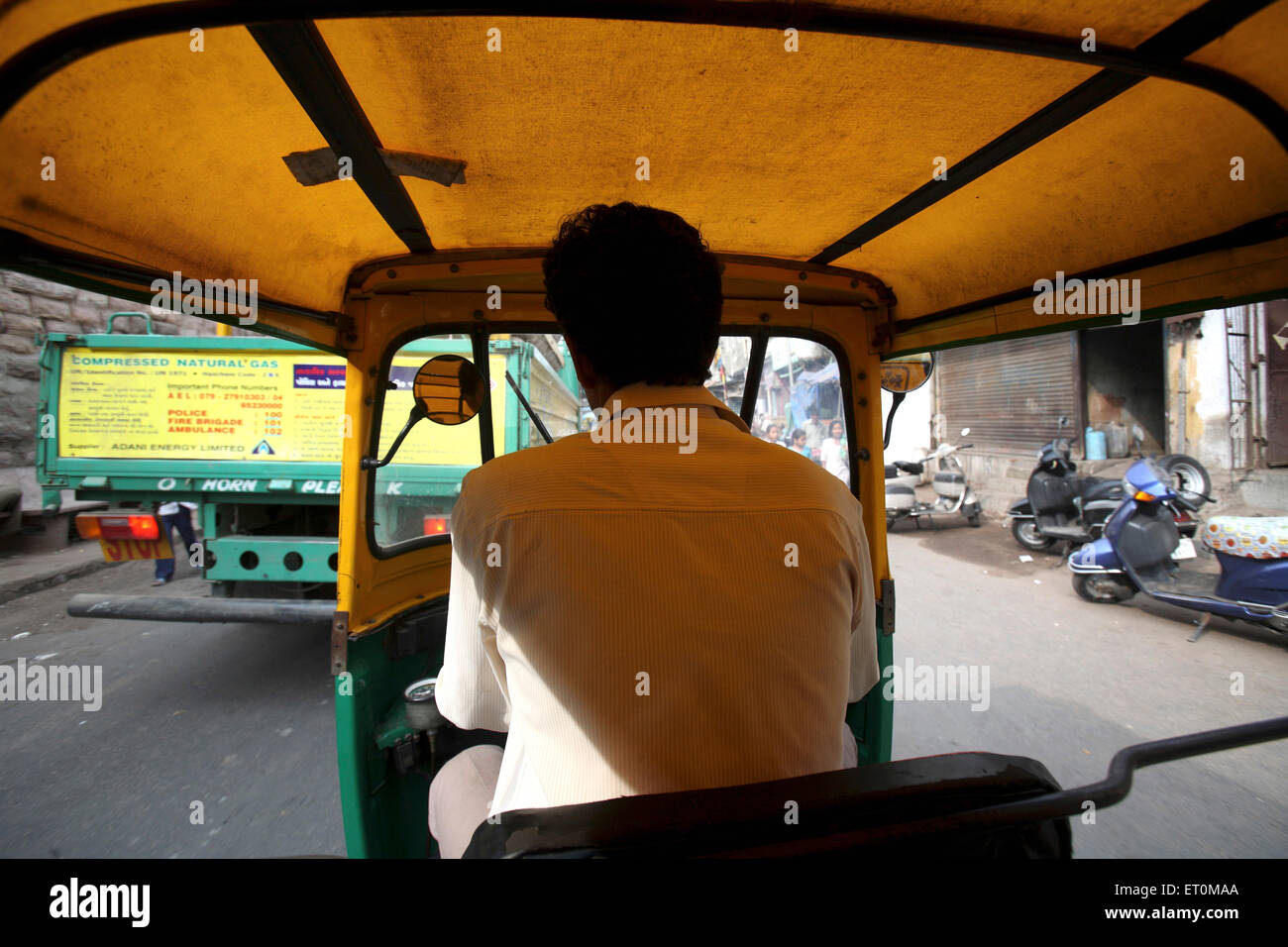 Auto rickshaw driver di pilotaggio rickshaw su strade di India Foto Stock