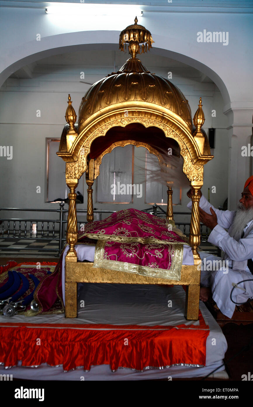 La religione sikh chierico onde di una frusta oltre il santo Guru Granth Sahib al Anandpur Sahib Gurudwara nel distretto di Rupnagar ; Punjab ; India Foto Stock