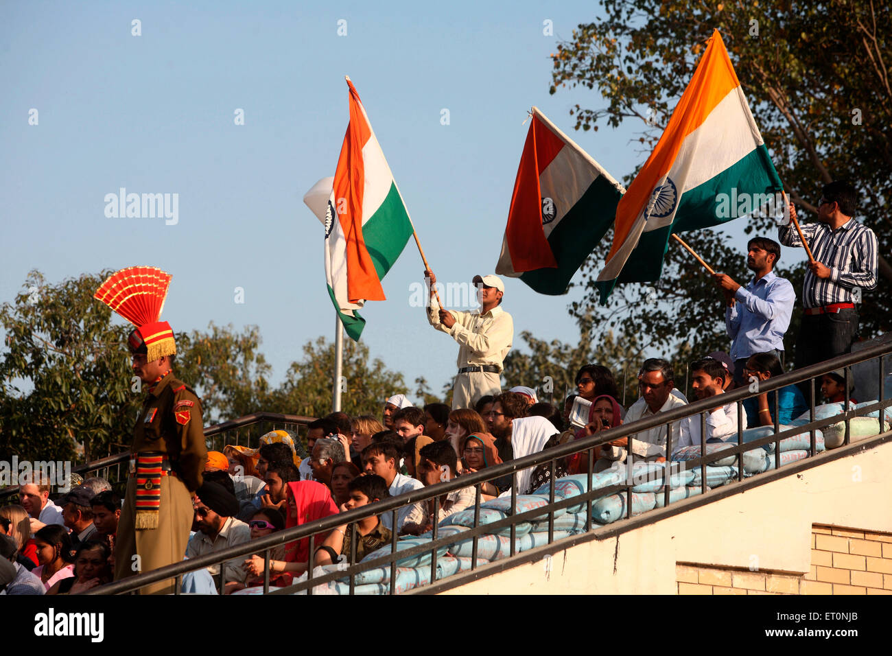 Folla holding bandiera indiana nel cambio della guardia al confine Wagah ; Amritsar ; Punjab ; India Foto Stock