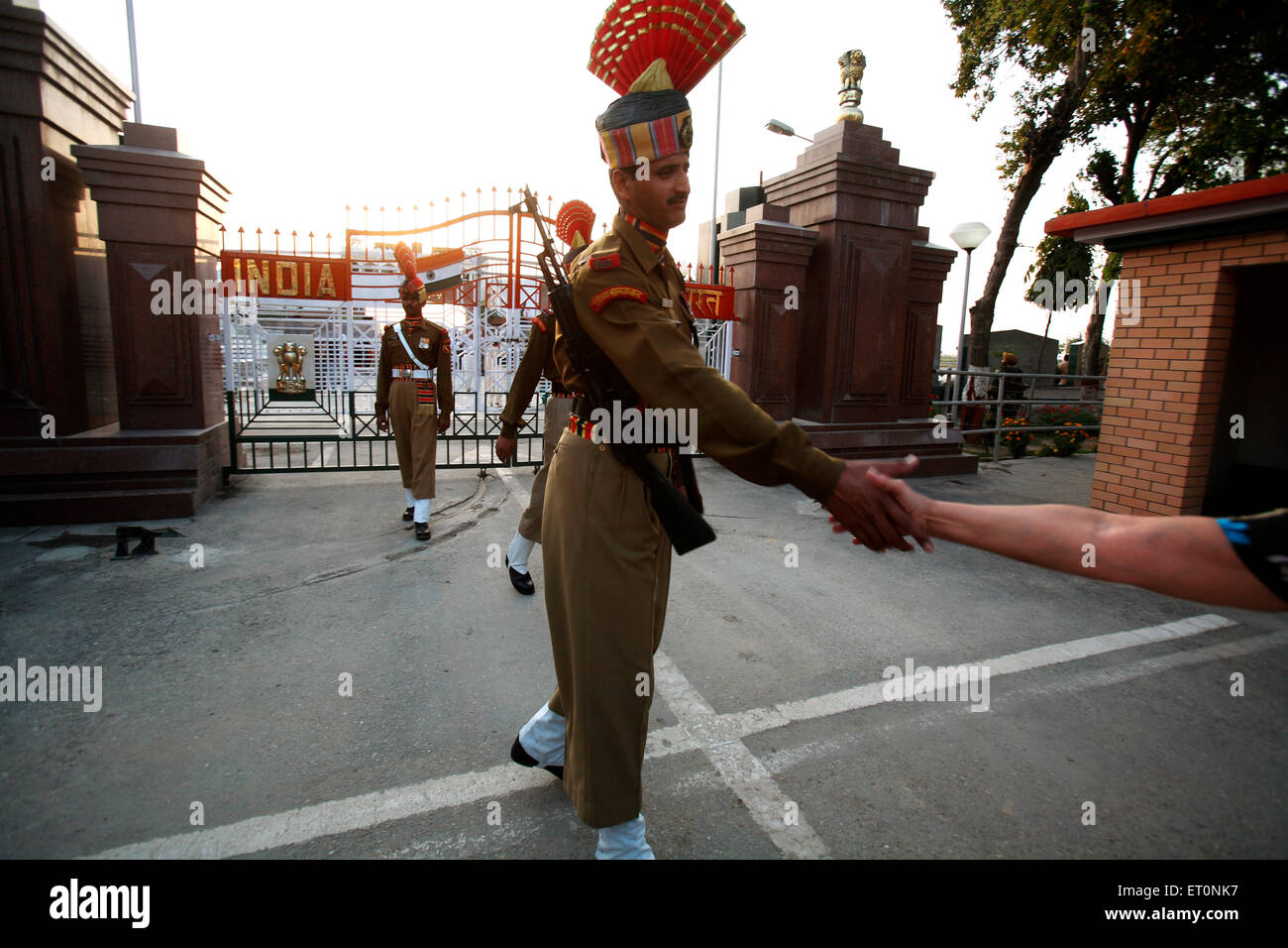 Confine indiano sicurezza force soldato agitando la mano con le persone durante la modifica della cerimonia di guardia di frontiera Wagah Foto Stock