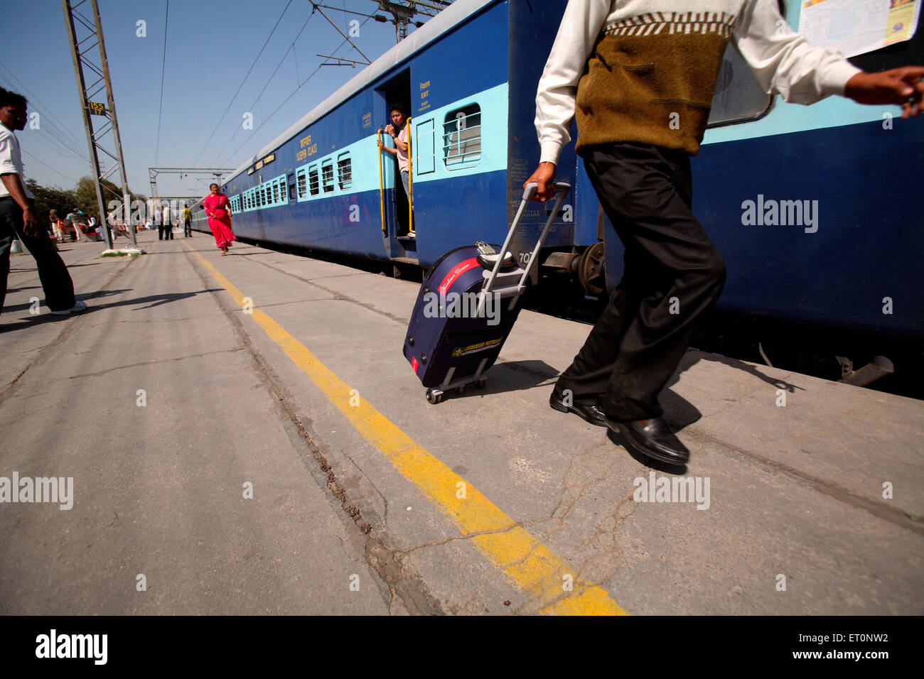 Passeggeri con trolley borsa alla stazione ferroviaria in India Foto Stock