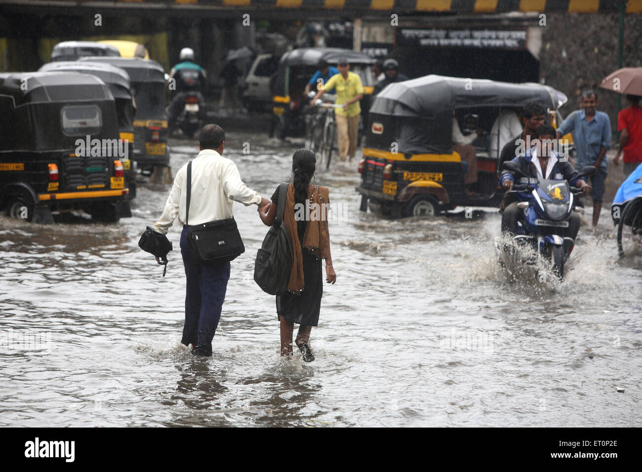 Giovane a piedi in acqua piovana a Andheri ; Mumbai Bombay ; Maharashtra ; India Foto Stock