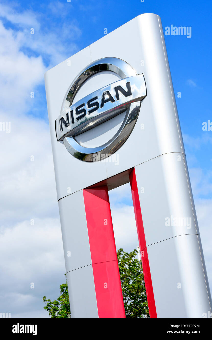Il logo aziendale del concessionario di auto Nissan e l'indicatore del marchio si trovano all'esterno del nuovo showroom di auto al dettaglio, compreso il centro di assistenza a East London, Inghilterra, Regno Unito Foto Stock