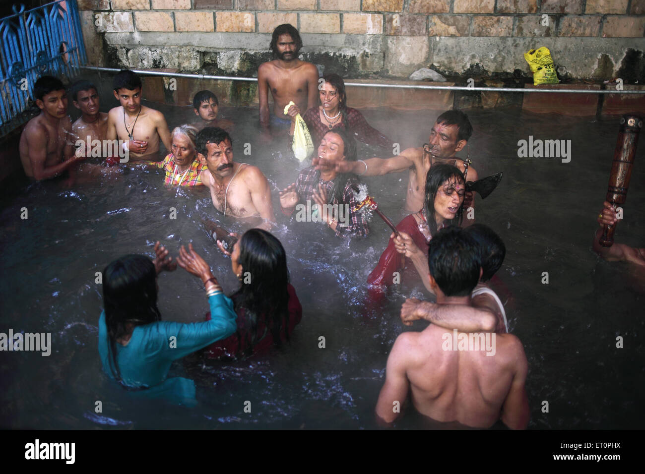 I devoti tenendo bagno in yamuna bai kund serbatoio acqua a garhwal himalaya ; Uttarkashi ; Uttarakhand ; India NOMR Foto Stock