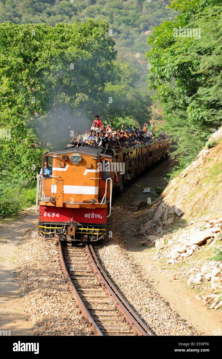 Locomotiva in pista ; persone che siedono sul tetto , Goram Ghat ; Marwar Junction ; Rajasthan ; India , Asia Foto Stock