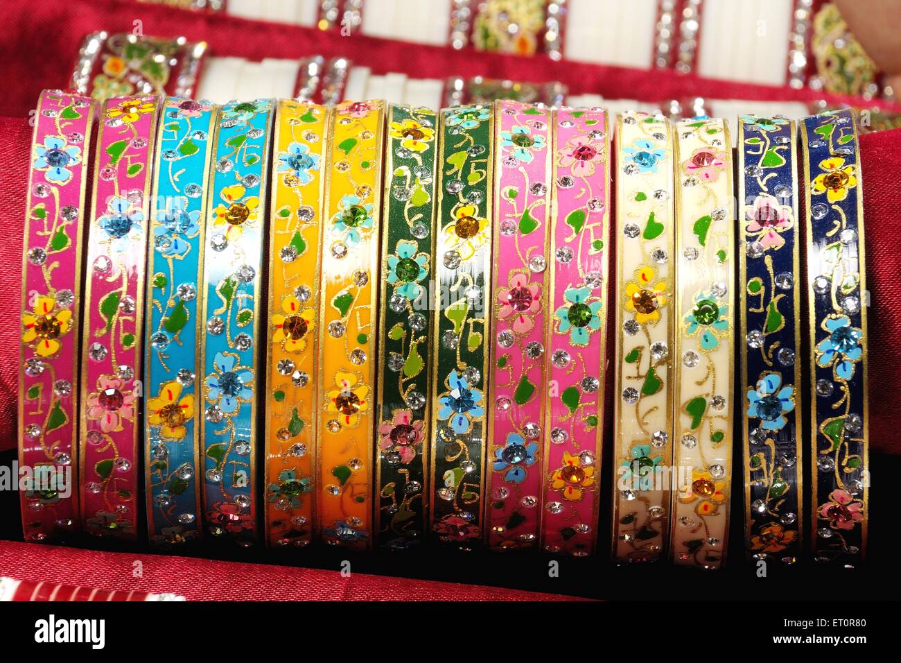Colorati bangle in metallo verniciato su sfondo rosso Foto Stock