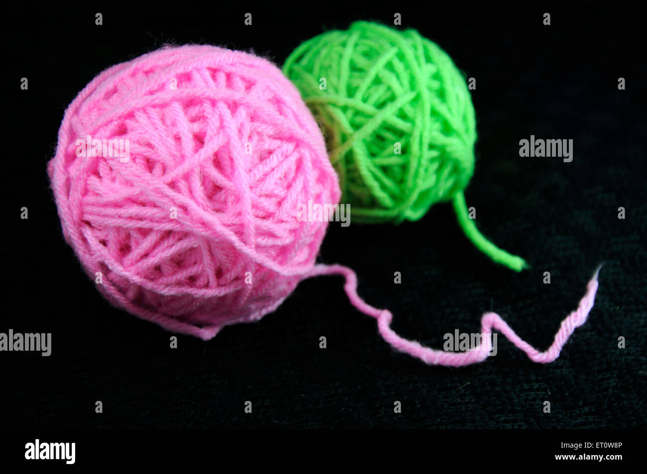 Di colore verde e rosa filati di lana palla su sfondo nero in India Asia Foto Stock