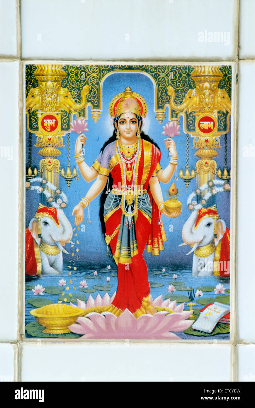 Dea Lakshmi di ricchezza in piedi su piastrelle dipinte di fiori di loto Foto Stock