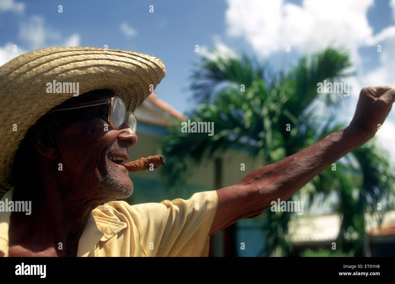 Pomeriggio Il fumo El guajiro rimorchiatori il fumo dolce dal suo sigaro mentre si guarda oltre il suo villaggio, Pinar del Rio, Cuba. Foto Stock