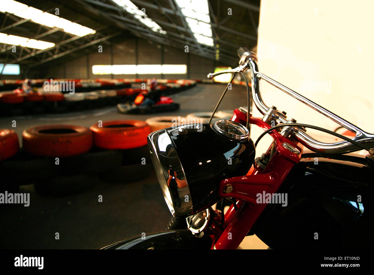 Vintage bike ciclomotore in karting hall e carretti giong sullo sfondo Foto Stock