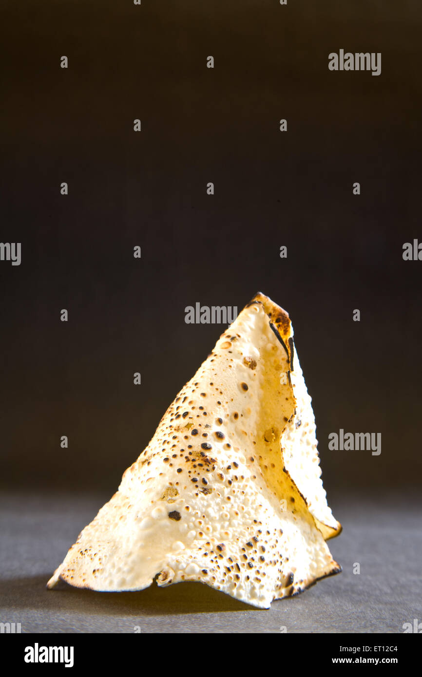 papad arrosto, papadum, papadom, snack indiano, cracker, forma conica, sfondo nero Foto Stock