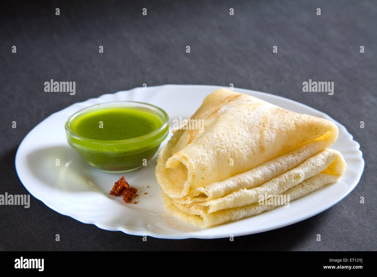 Il fast food rawa masala dosa con chutney di coriandolo servita nel piatto su sfondo grigio 19 Maggio 2010 Foto Stock