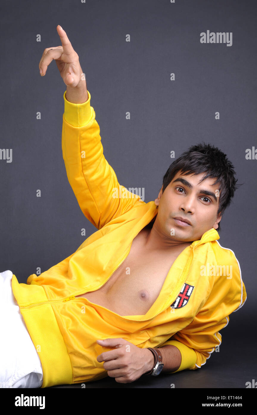 Uomo in aperto maglia gialla ha sollevato il braccio puntando con il dito il signor#719G Foto Stock