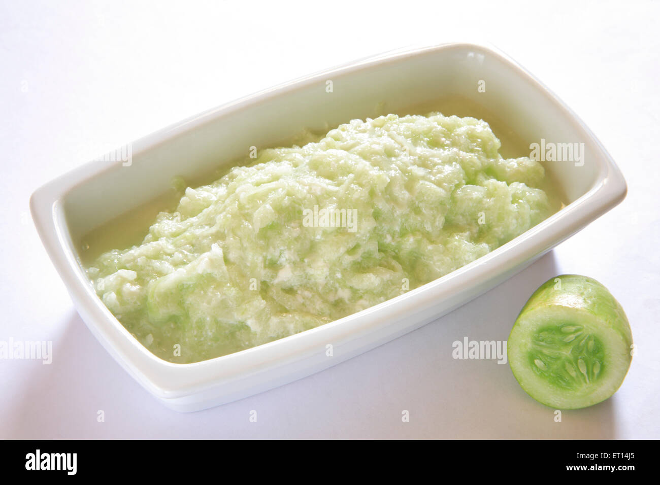 Insalata di verdure ; il cetriolo e latticini kakri ka raita guarnire con foglie di coriandolo in rettangolo piastra su sfondo bianco Foto Stock