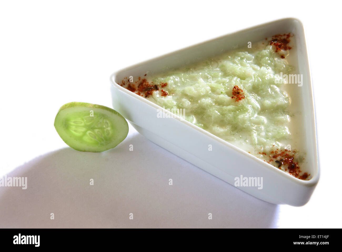 Insalata di verdure ; il cetriolo e latticini kakri ka raita speziato con peperoncino in polvere nella piastra triangolare su sfondo bianco Foto Stock