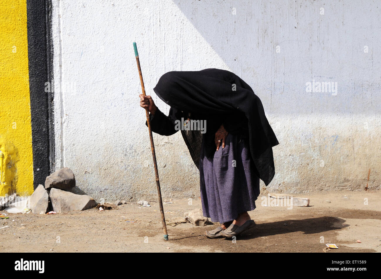 Vecchia donna, piegata con l'età, camminando con bastone, Mindiyada, Anjar, Kachchh, Kutch, Gujarat, India Foto Stock