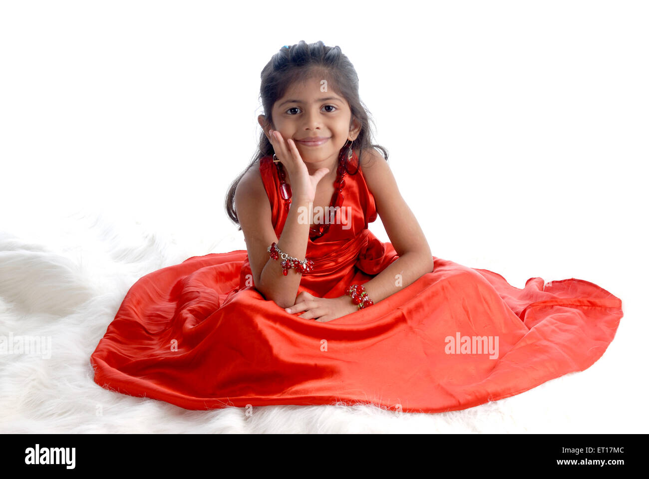 Indian Baby girl bambino seduto mano sulla faccia abito rosso sfondo bianco - signor#736m - rmm 151197 Foto Stock