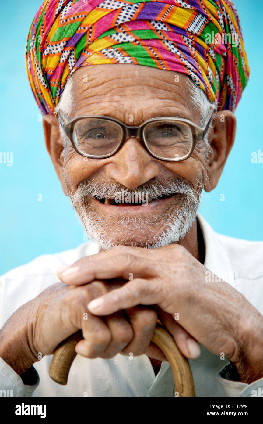Il vecchio uomo di ridere in appoggio su Stick Rajasthan India Asia signor#784B Foto Stock