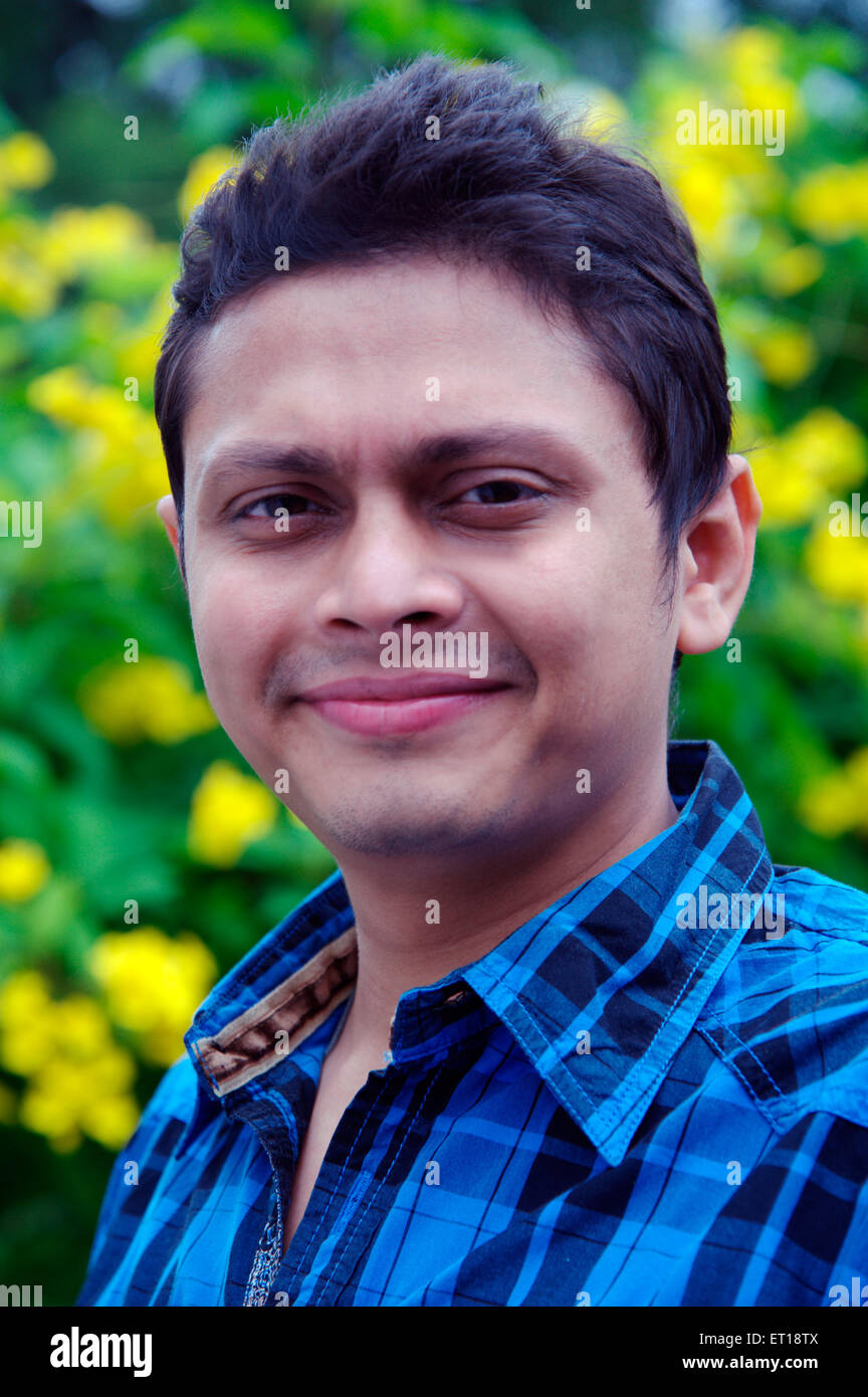 Indian giovane faccia verticale maglietta blu verde giallo giardino di sfondo - signor#782 - 179841 rmm Foto Stock
