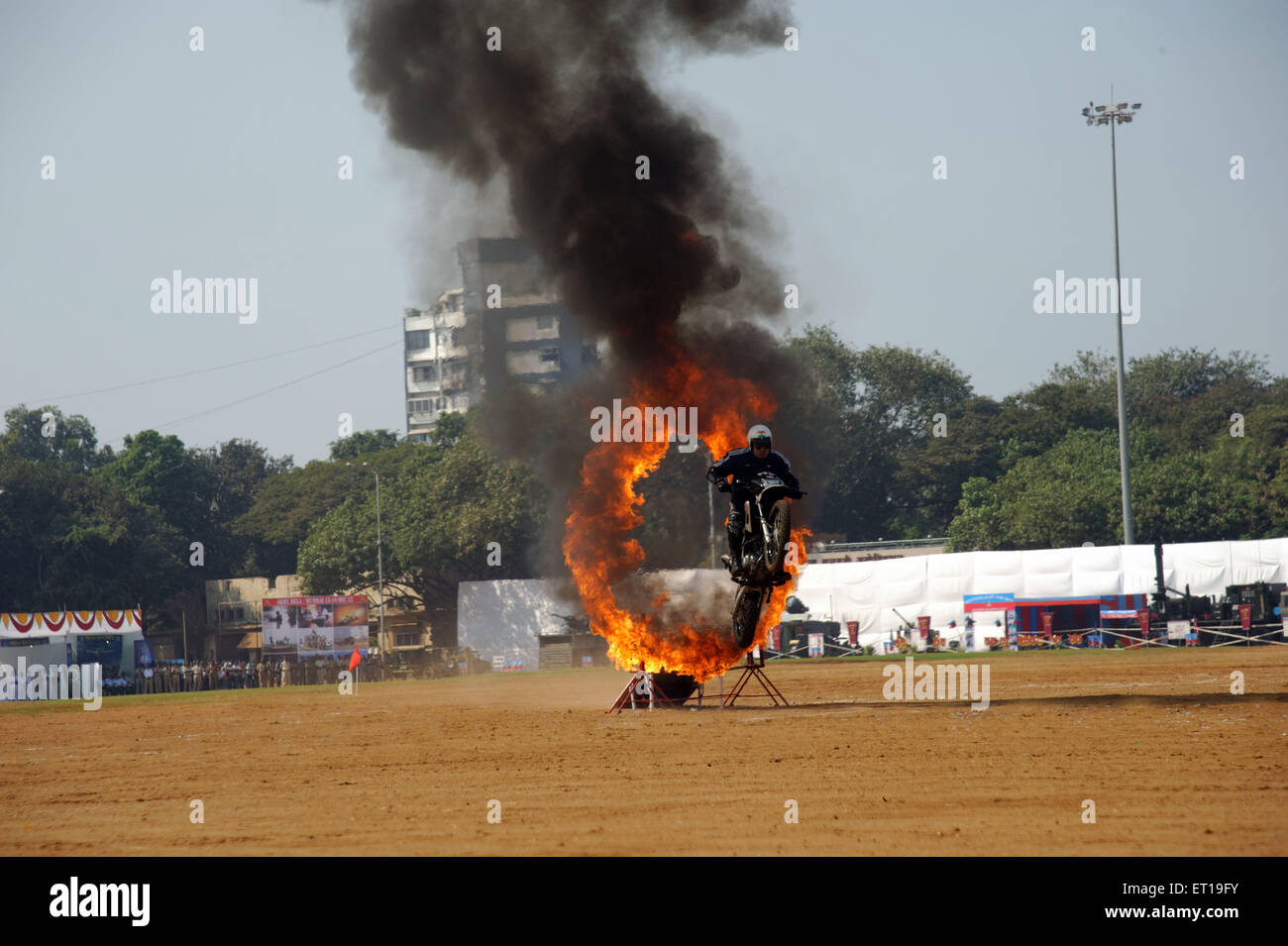 Uomini Salto con la bici attraverso l'anello di fuoco il giorno della repubblica mumbai Maharashtra India Asia Foto Stock