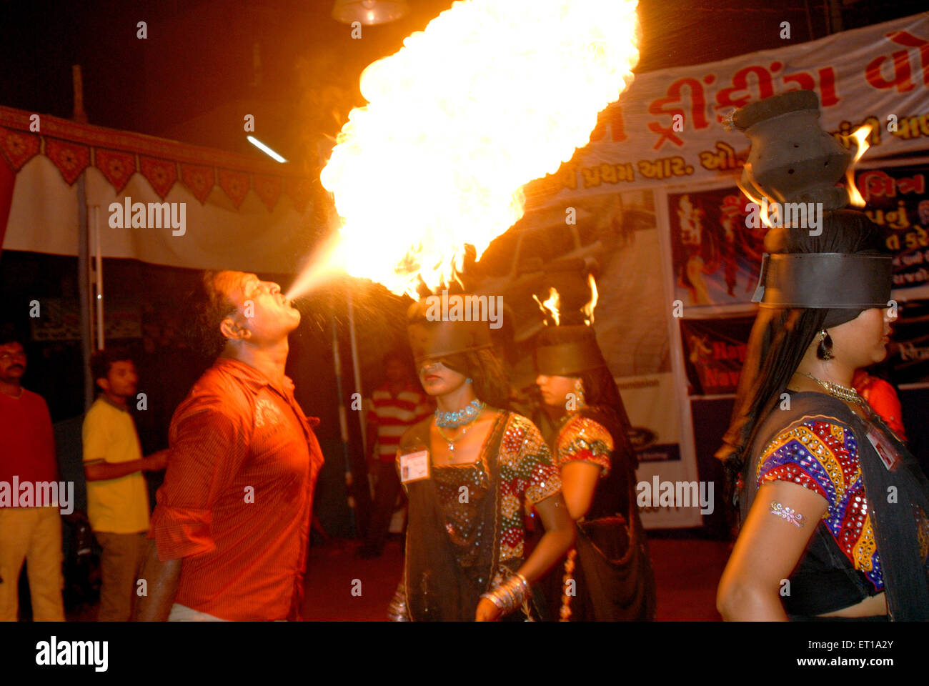 Ragazza gli occhi coperti e uomo soffiando sul fuoco navaratri festival ; Rajkot ; Gujarat ; India Signor#781c;781D;781E;781G;781H;781I Foto Stock